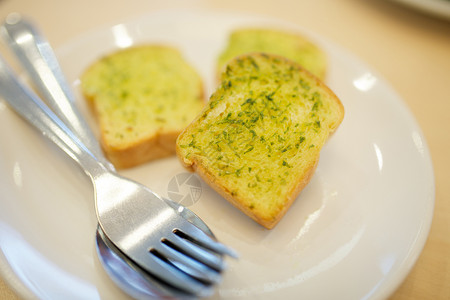 大蒜和香草面包勺子硬皮白色食物草本植物香菜黄油盘子背景图片