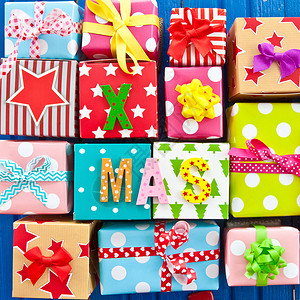 小礼物包裹在彩色纸纸上圣诞礼物条纹贺卡丝带喜悦圆点包装纸礼品包装星星背景图片