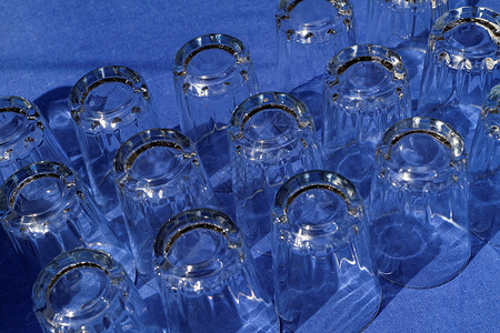 多玻璃杯器皿派对饮料桌布反射瓶子蓝色玻璃液体背景图片