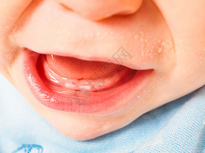 婴儿嘴婴儿男孩用张嘴张开嘴巴 露出第一口牙齿背景