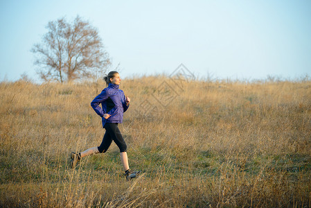 青年体育女青年在秋日田径上奔跑踪迹慢跑者闲暇锻炼蓝色女孩农村运动员场地女性背景图片