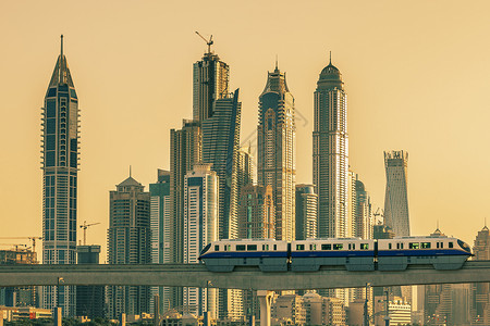 迪拜日落时有地铁和摩天大楼背景图片