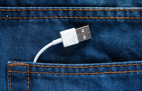 牛仔裤口袋中的 USB 数据线背景图片