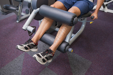 使用称重机处理腿部重量的健身人运动服训练健身房运动身体娱乐男人健身室闲暇举重机背景图片