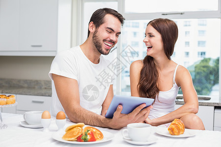 早餐时用药片的年轻夫妇男朋友女性男性房子夫妻男人微笑住所闲暇家庭生活背景图片