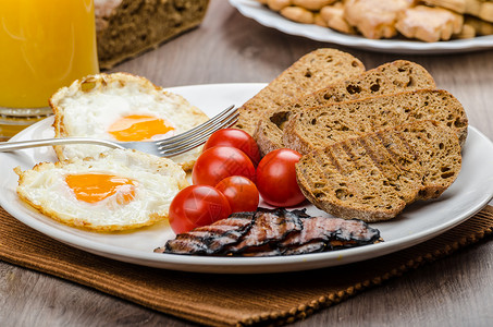 早餐培根 香肠 面包和鸡蛋橙子火腿果汁英语食物用餐桌子带子蛋黄油炸背景图片