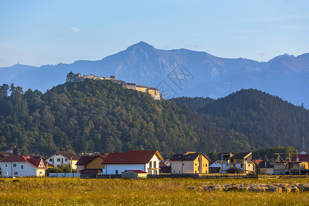 罗马尼亚拉斯诺夫堡垒和布塞吉山地标建筑学爬坡建筑物环境山脉蓝色考古学牧场地平线背景
