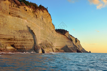 海岸上的岩石旅行地平线石头悬崖植物旅游太阳背景图片