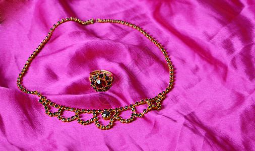 首饰套件金子戒指丝绸紫色织物纺织品奢华布料宝石珠宝背景图片