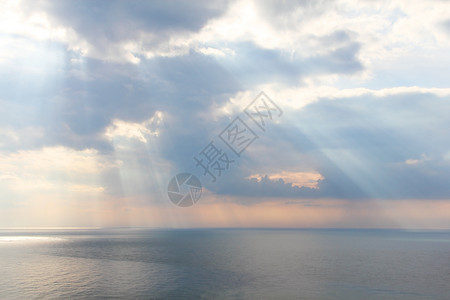 光线穿透海云戏剧性日出海洋海岸射线天气上帝天堂蓝色日落背景图片