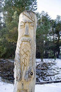 奥丁蓝色多云背景下的图腾木杆雕塑仪式木头上帝艺术面具精神国家文化动物背景