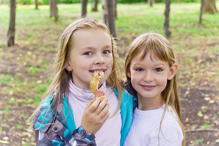 两个吃女孩的可爱女学生童年金发白色孩子女性背景图片