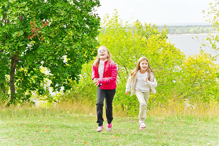 可爱两个跑跑的女生闲暇跑步行动舞蹈孩子微笑休闲白色运动女性背景图片