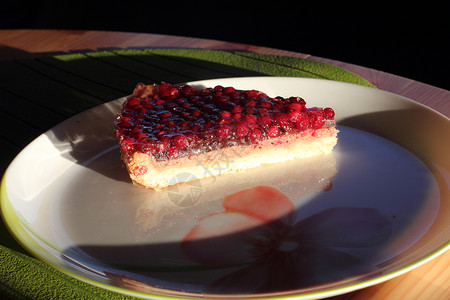 一块小蛋糕 夹着红莓盘子面团食物浆果绿色红色背景图片