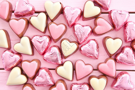 心形形状中的多彩巧克力水平生日款待糖果粉色婚礼食物背景