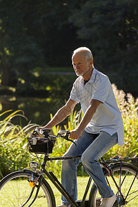 高级骑士自行车活动闲暇乡村骑术退休运动牛仔裤阳光男人娱乐背景图片