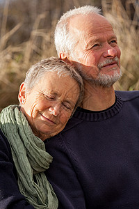 快乐的老年情侣在阳光下一起放松晴天闲暇家庭天空老化生活中年情感成人女性背景图片