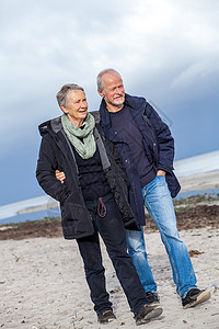 快乐的老年老人夫妇在海滩上散步退休女士娱乐友谊男人海岸夫妻丈夫妻子背景图片