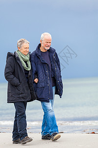 快乐的老年老人夫妇在海滩上散步女士夫妻海岸退休友谊丈夫妻子娱乐男人背景图片