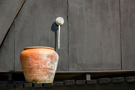 橙色水 旧木墙的黑色背景阳台阳光木头水缸房子木板背景图片