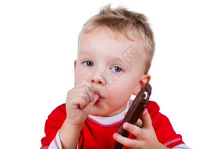 小男孩吃着一整块巧克力棕色金发微笑快乐孩子喜悦糖果乐趣食物甜点背景图片