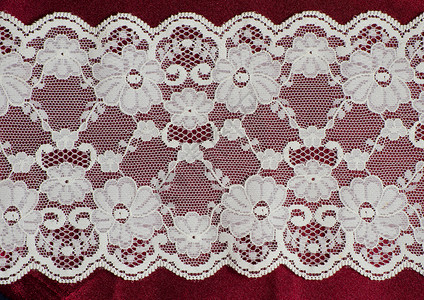 红色派边织物上的蕾丝边框材料装饰缝纫丝绸花边背景图片