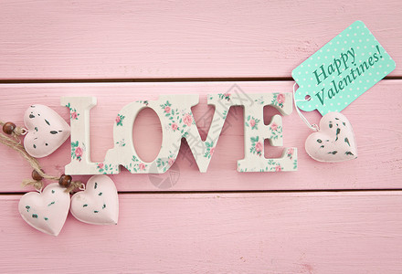 粉红木背景的爱礼品木头心形花卉标签刻字乡村粉色圆点图案背景图片