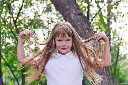 玩长头发的可爱女孩头发女学生孩子白色童年背景图片