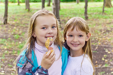 两个吃女孩的可爱女性孩子童年金发白色女学生背景图片