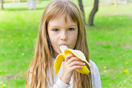女孩在吃香蕉童年女学生白色孩子背景图片