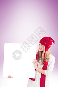 展示白海报的金发美女帽子微笑广告服装开襟衫休闲卡片保暖头发浅色背景图片