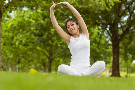 定调子健康的女子在公园伸手绿地身体双腿拉伸闲暇运动训练活动女性体力背景