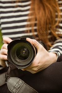 女摄影师的中间部单反技术爱好相机镜片女性闲暇摄影背景图片