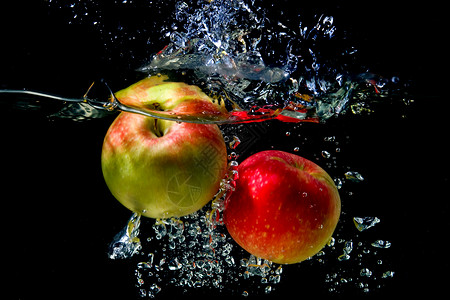 苹果掉入水中红色背景飞溅黑色绿色液体水果运动食物水滴背景图片