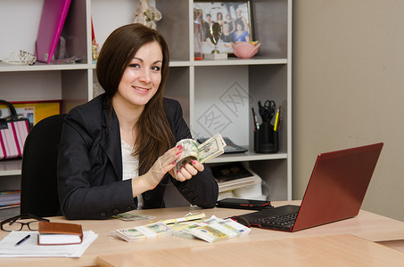 一包钱素材在办公室的女孩 快乐地把钱转成一包背景