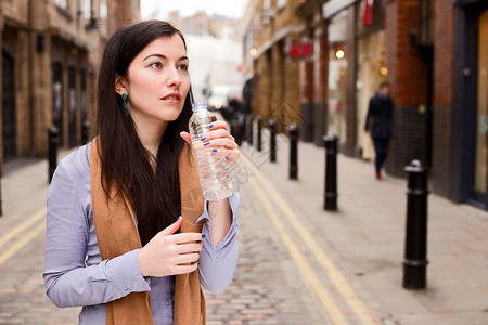 饮用水瓶装饮料塑料成人女性矿物瓶子闲暇享受城市生活背景图片