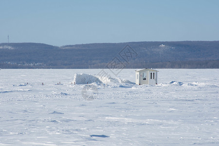 冰冻湖上的冰钓小屋高清图片