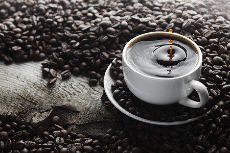 咖啡在杯子中泼花黑色芳香棕色饮料木头运动桌子白色香气液体背景图片