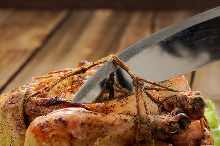 刀线在木本底烤鸡 切翅膀缠绕绑扎束缚家禽切割线厨师盘子包装木材背景