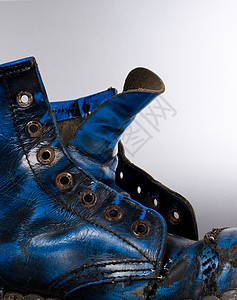 旧旧靴子皮革蕾丝蓝色黑色背景图片