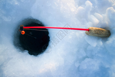 雪玉洞手工捕鱼的冰鱼脚手架活动太阳乐趣荒野冰钓鲈鱼爱好垂钓者运动背景