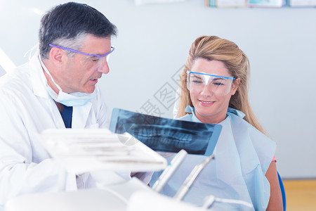 向病人展示X光的牙医实验护士口腔诊所互动牙科保健女士男性男人背景图片