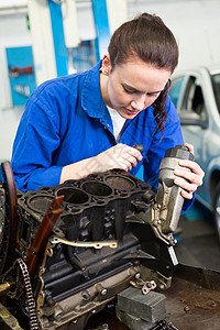 在发动机上工作的机械服务修理车库女士车辆汽车工人工作服女性机械师背景图片