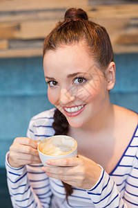 有卡布奇诺的年轻女子咖啡屋女性快乐食堂行业饮料活动咖啡店女孩杯子背景图片