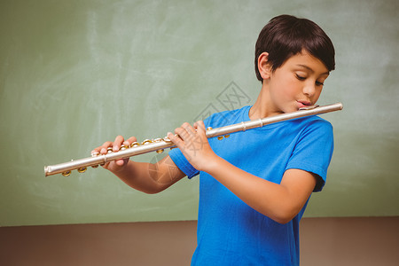 小男孩在教室里玩长笛课堂学习班级学生童年乐器智力混血教育爱好背景图片