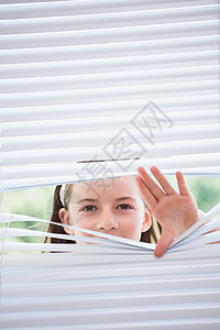 小女孩透过百叶窗偷看闲暇间谍白色女性女孩窗户好奇心住所童年家庭生活背景图片