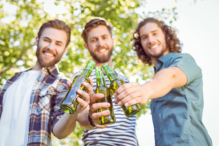 时髦的朋友一起喝啤酒阳光男人潮人啤酒社交微笑友谊晴天瓶子胡须背景图片