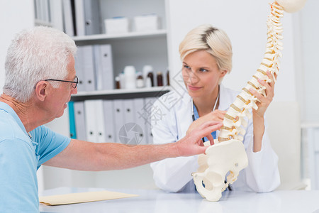 高级病人向表列医生显示脊椎问题背景图片