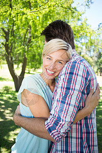 快乐的情侣拥抱公园女士女性活动晴天成人夫妻微笑感情男人阳光背景图片