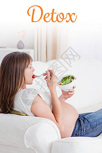 对躺在沙发上吃沙拉的 美丽的孕妇进行戒毒治疗背景图片